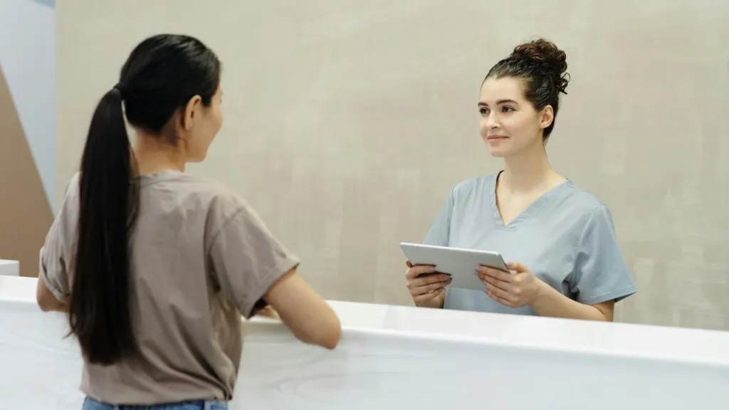 Recepção moderna de consultório odontológico com atendimento humanizado e tecnologia integrada para melhorar a experiência do paciente.