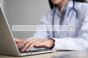 Médica pesquisando em um notebook, ilustrando a importância do Google Meu Negócio para clínicas encontrarem novos pacientes.