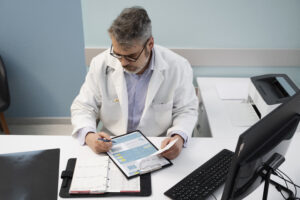 Gestor de clínica analisando dados de LTV e reativação de pacientes em tablet.